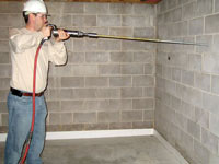 Coring a 1 inch hole in a basement wall to allow for the earth channel anchor rod to pass through.